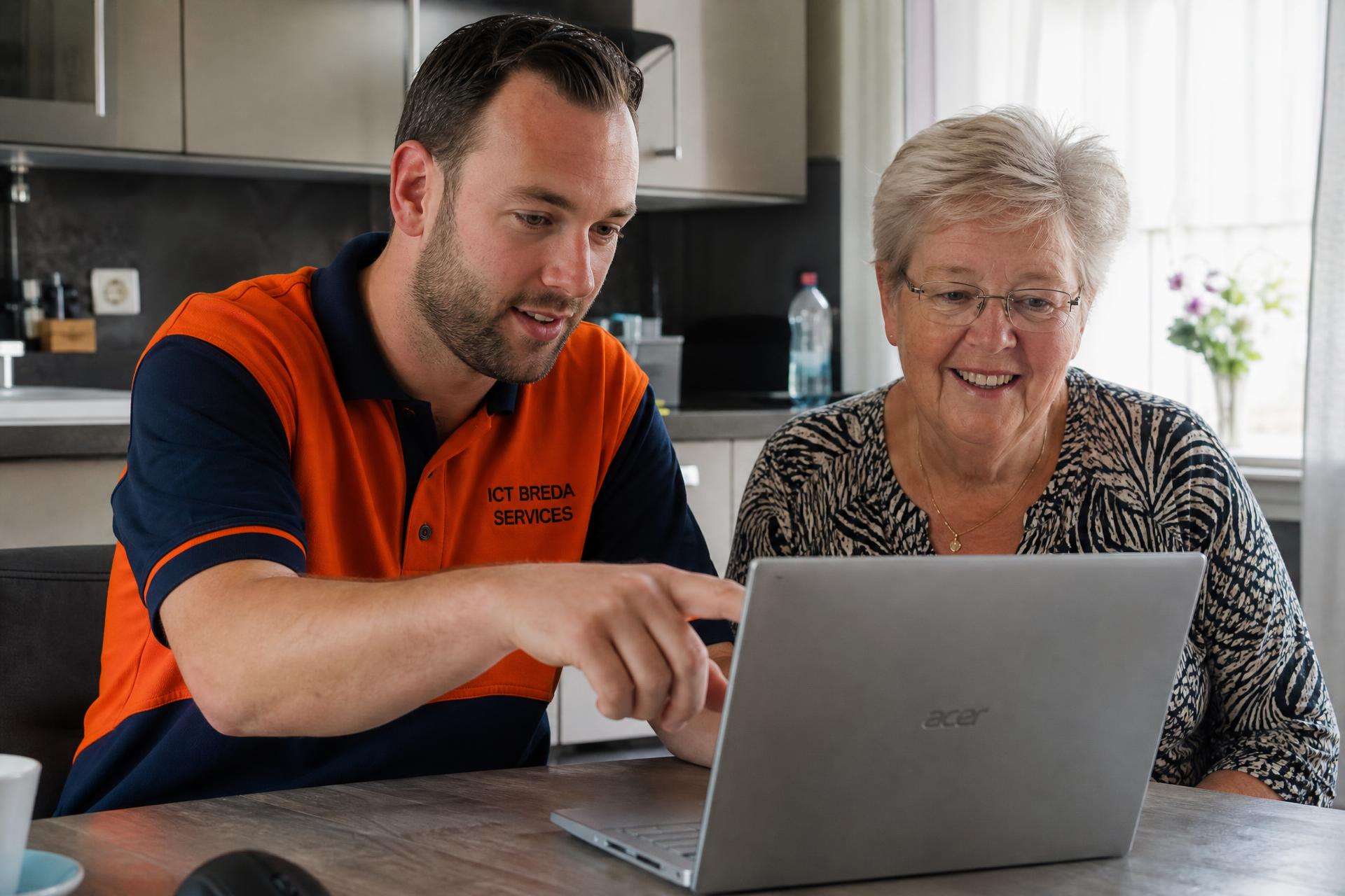 ICT-er helpt klant aan huis met laptop in Breda